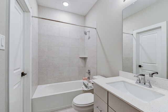 full bathroom featuring tiled shower / bath combo, toilet, and vanity