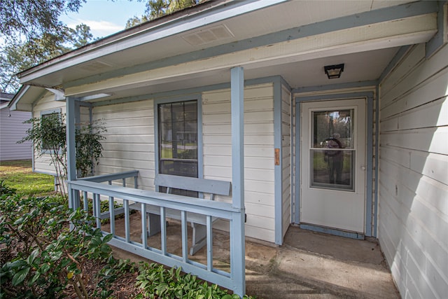 view of exterior entry featuring covered porch