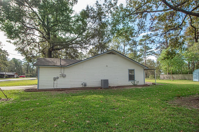 view of side of property with central air condition unit, fence, and a lawn