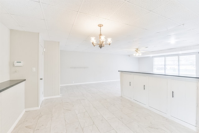 unfurnished room featuring ceiling fan with notable chandelier and a paneled ceiling