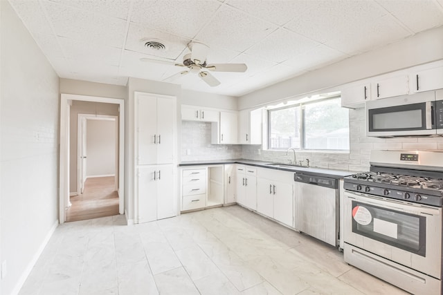 kitchen with sink, white cabinetry, backsplash, and appliances with stainless steel finishes