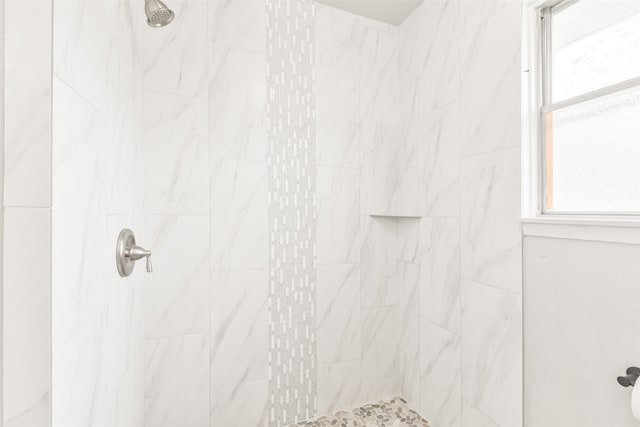 bathroom with a healthy amount of sunlight and tiled shower