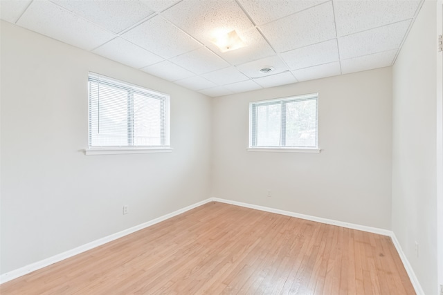 unfurnished room featuring a paneled ceiling and light wood-type flooring