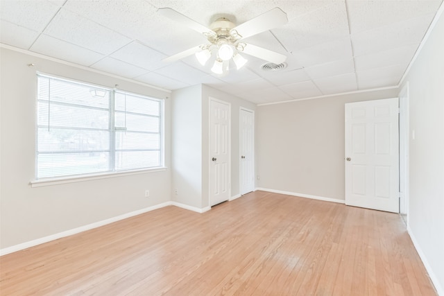 spare room with a paneled ceiling, ceiling fan, and light wood-type flooring