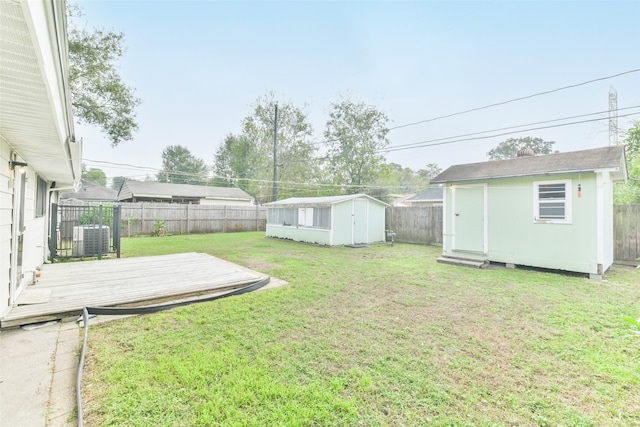 view of yard with a deck, a storage unit, and cooling unit