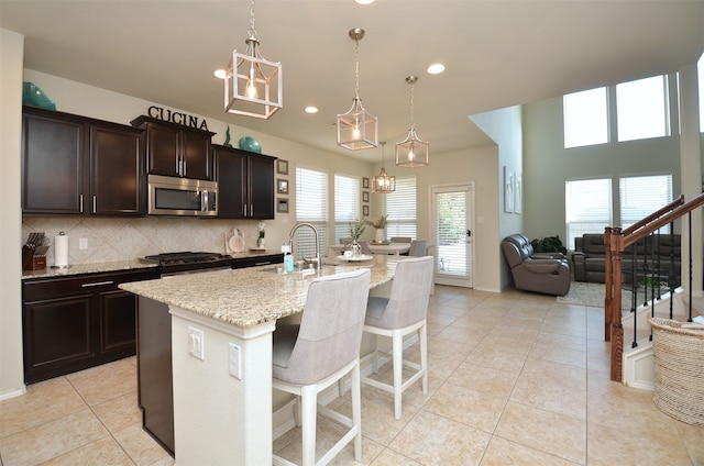 kitchen featuring plenty of natural light, a kitchen island with sink, and hanging light fixtures