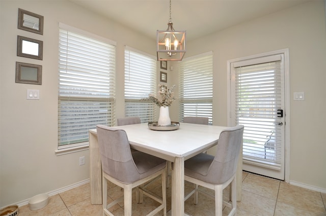 tiled dining room with an inviting chandelier