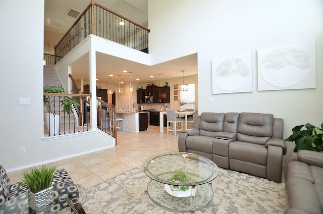 living room with plenty of natural light, light tile patterned floors, and a high ceiling