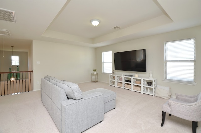 carpeted living room featuring a tray ceiling