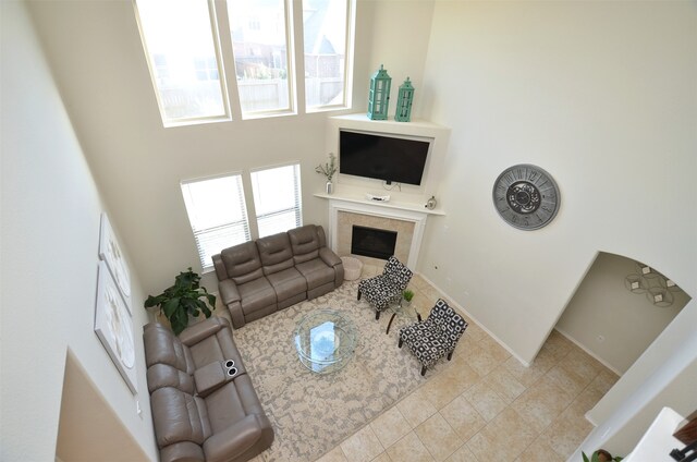 living room with a high ceiling and a tiled fireplace