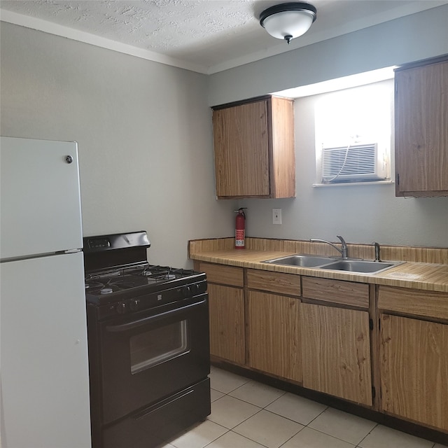 kitchen with sink, black gas stove, white fridge, a textured ceiling, and light tile patterned floors