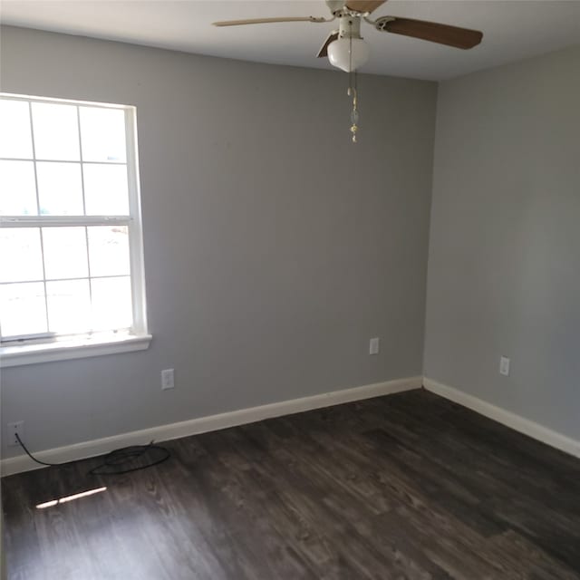 spare room featuring a wealth of natural light, dark wood-type flooring, and ceiling fan