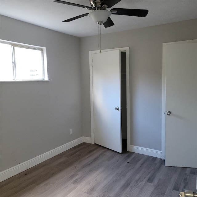 unfurnished bedroom with a closet, light hardwood / wood-style flooring, and ceiling fan