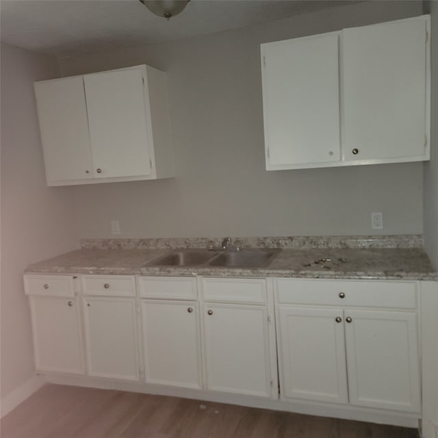 kitchen featuring white cabinets, hardwood / wood-style floors, and sink