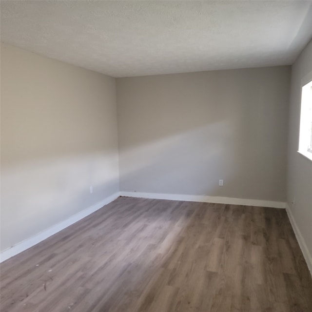 spare room with wood-type flooring and a textured ceiling