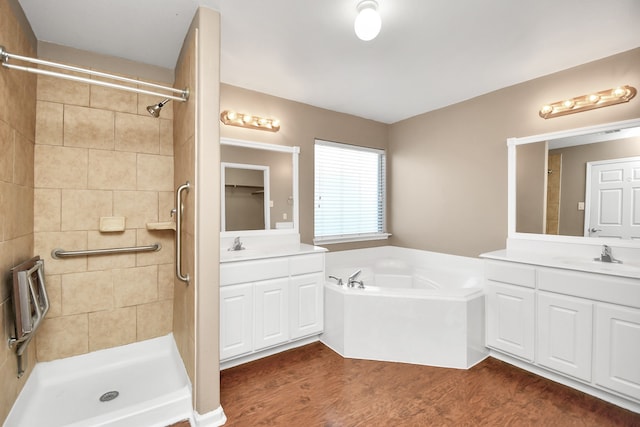 bathroom with hardwood / wood-style floors, vanity, and shower with separate bathtub