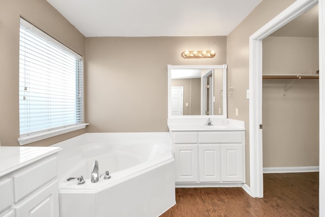 bathroom featuring a tub, hardwood / wood-style floors, and vanity