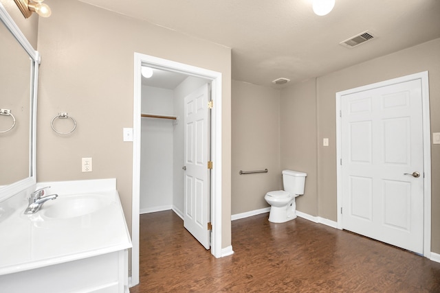 bathroom with vanity, wood-type flooring, and toilet