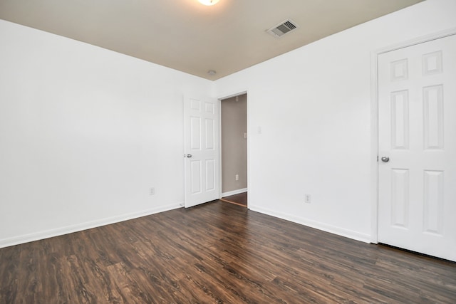 unfurnished room with dark wood-type flooring