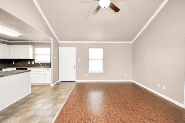 kitchen featuring decorative backsplash, white cabinetry, a wealth of natural light, and light hardwood / wood-style flooring