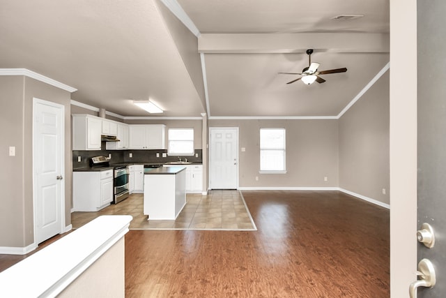 kitchen featuring electric stove, beam ceiling, tasteful backsplash, light hardwood / wood-style floors, and white cabinetry