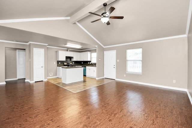 unfurnished living room with ceiling fan, dark hardwood / wood-style flooring, beamed ceiling, and ornamental molding