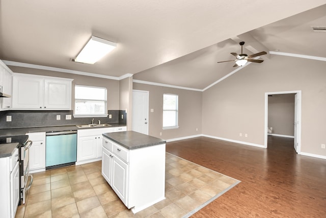 kitchen with a center island, stainless steel appliances, white cabinetry, and a wealth of natural light