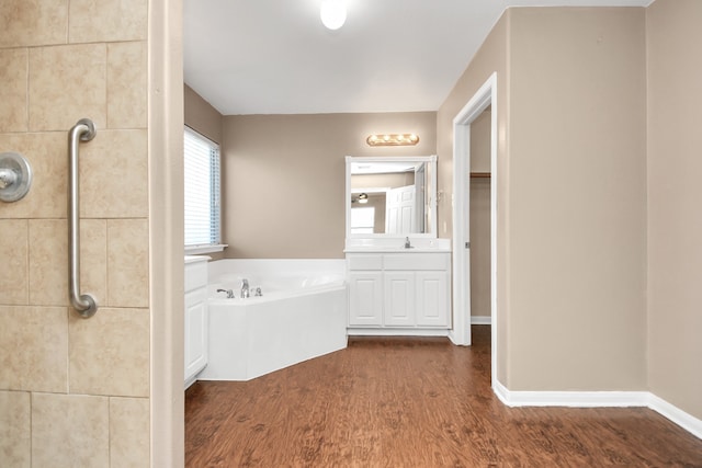 bathroom featuring hardwood / wood-style flooring, vanity, and a bathing tub