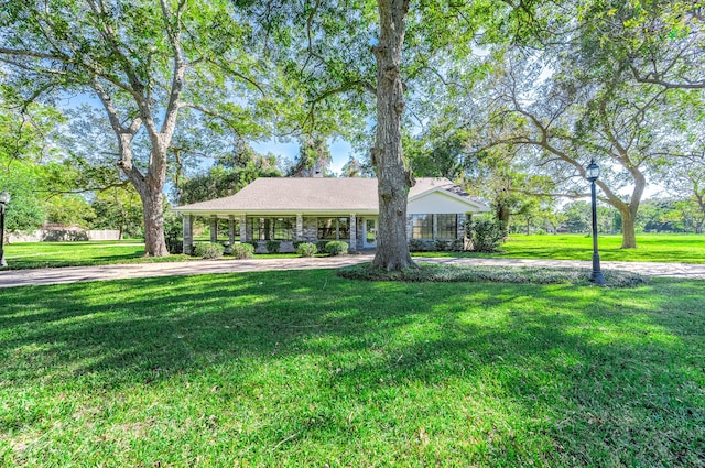 ranch-style home featuring a porch and a front lawn