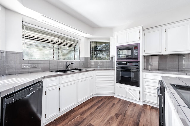 kitchen featuring white cabinets, tile countertops, and black appliances