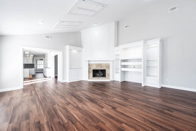 unfurnished living room with built in shelves, an inviting chandelier, high vaulted ceiling, dark hardwood / wood-style floors, and a fireplace