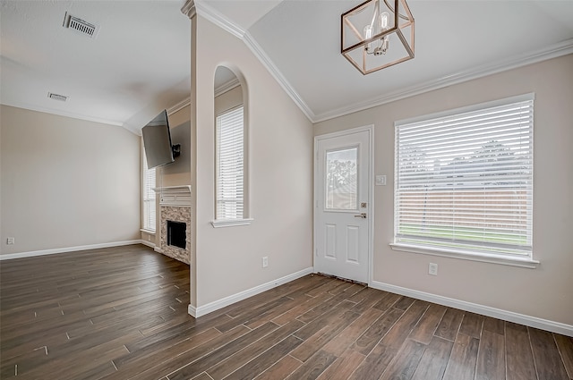 entryway with plenty of natural light, a fireplace, ornamental molding, and dark wood-type flooring