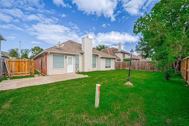 rear view of house featuring a yard and a patio