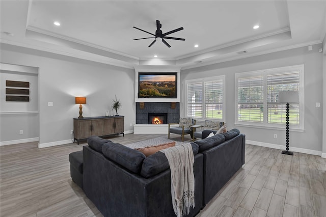 living room featuring a tray ceiling and light hardwood / wood-style flooring