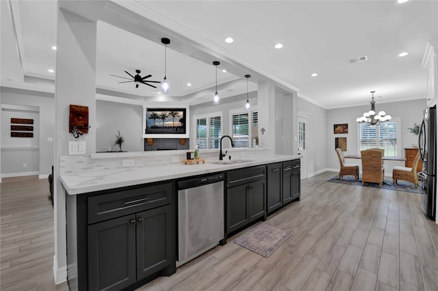 kitchen with ceiling fan with notable chandelier, hanging light fixtures, light wood-type flooring, appliances with stainless steel finishes, and light stone counters