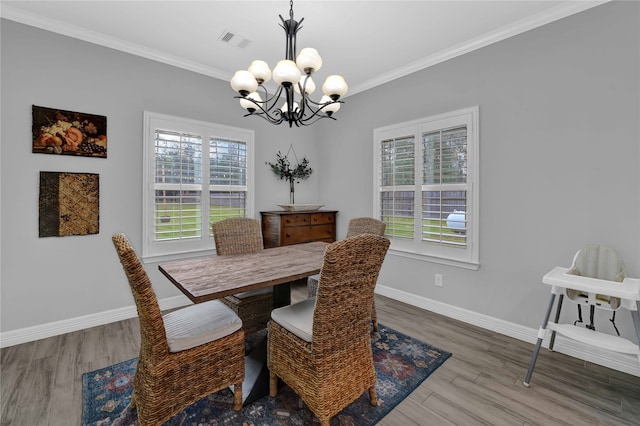 dining space featuring hardwood / wood-style floors, a chandelier, and ornamental molding