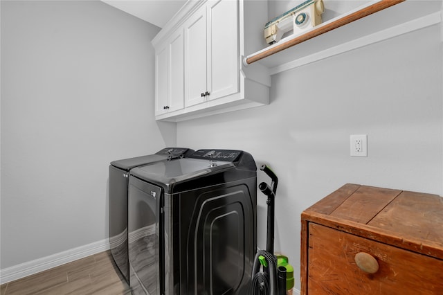 washroom with separate washer and dryer, cabinets, and light wood-type flooring