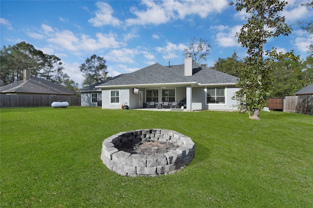 rear view of property with a lawn, a patio, and an outdoor fire pit