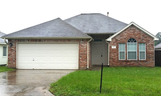 view of front of property featuring a garage and a front lawn