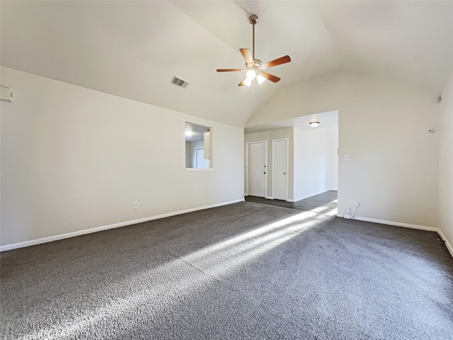 empty room featuring dark carpet, vaulted ceiling, and ceiling fan