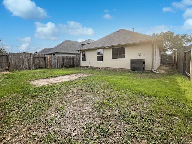 rear view of property with cooling unit and a lawn