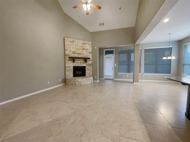 unfurnished living room with a fireplace, ceiling fan with notable chandelier, high vaulted ceiling, and light tile patterned flooring