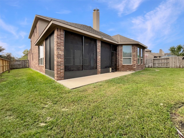 rear view of property featuring a lawn and a patio area