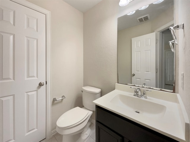 bathroom with tile patterned flooring, vanity, and toilet