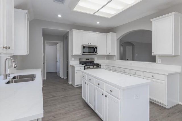 kitchen with appliances with stainless steel finishes, white cabinets, and a kitchen island