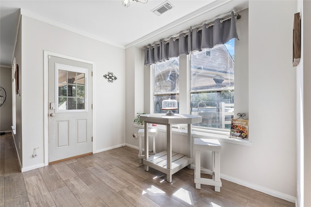 entrance foyer featuring visible vents, a wealth of natural light, and ornamental molding