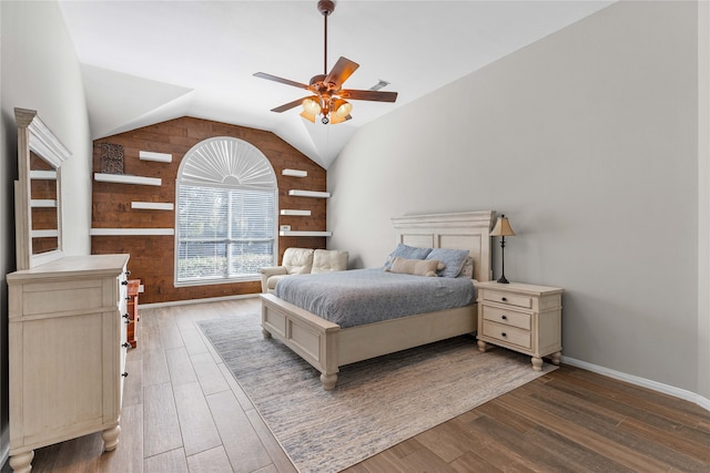 bedroom with baseboards, visible vents, dark wood finished floors, a ceiling fan, and vaulted ceiling