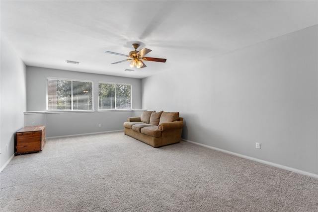 sitting room with light colored carpet, visible vents, ceiling fan, and baseboards