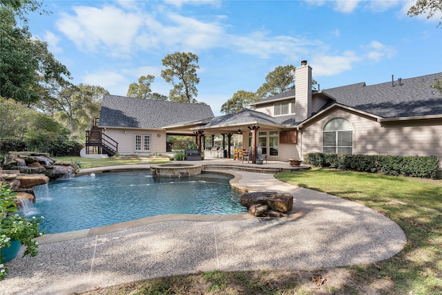 view of swimming pool with an in ground hot tub, french doors, pool water feature, a patio, and a lawn