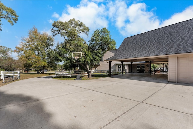 view of patio featuring driveway, fence, and an attached carport